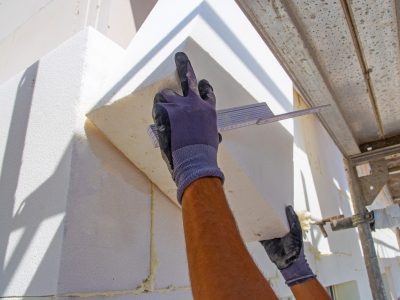 Bauarbeiter isolieren eine Hausfassade